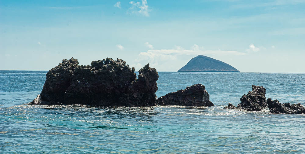 Coast of Floreana Island. Volcanic cone in the background. Galapagos Island. Ecuador. South America.
